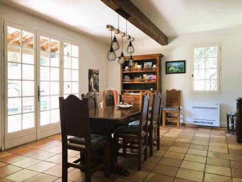 une salle à manger avec une table et des chaises dans l'établissement Villa provençale au calme entourée de verdure, animaux de compagnie acceptés !, à Belgentier