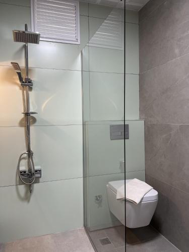 a bathroom with a glass shower with a toilet at Keyif Pension & Aparts in Cıralı