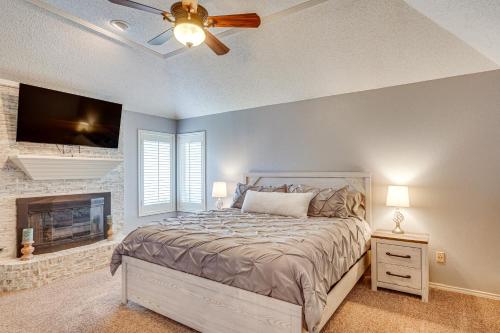 a bedroom with a bed with a ceiling fan and a fireplace at 8 Mi to Texas Tech Home with Patio in Lubbock in Lubbock