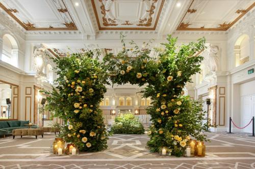 a group of trees in a lobby with flowers at Kimpton Fitzroy London by IHG in London