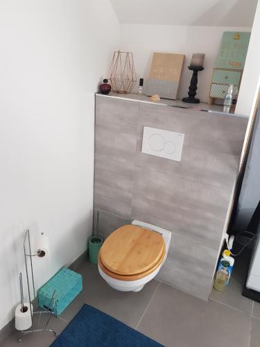 La salle de bains est pourvue de toilettes et d'un siège en bois. dans l'établissement Appartement lumineux avec terrasse proche Colmar, à Wihr-au-Val