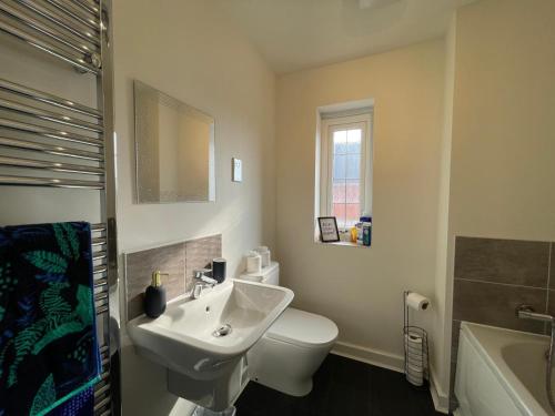 Down HatherleyにあるKale Drive House Long Stays Welcome Free Parking, Sleeps 6の白いトイレと洗面台のあるバスルーム