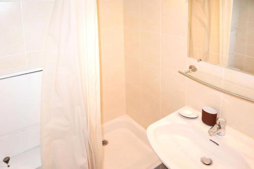 une salle de bain blanche avec un lavabo et une douche dans l'établissement Résidence Le Cairn - Studio pour 4 personnes MAE-2041, aux Orres