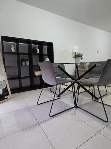 two chairs and a glass table in a room at Epicurian Residence in Nicosia