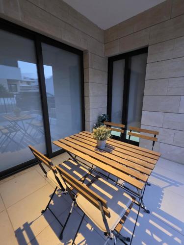 a wooden table and chairs on a balcony with windows at Epicurian Residence in Nicosia