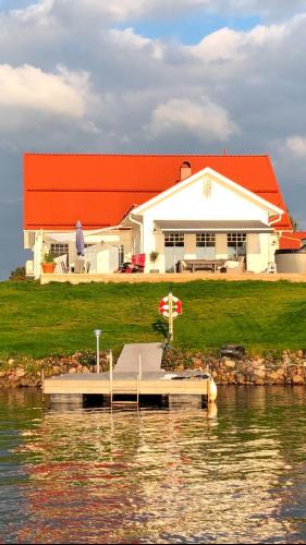 a house on the water with a dock in front at Northern Lights exclusive house by the river in Boden