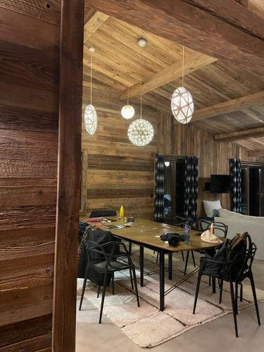 une salle à manger avec une table et des chaises noires dans l'établissement Le luxe sur les pistes, à Saint-Gervais-les-Bains