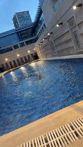 a large swimming pool in a building with buildings at Amman damac tower عبدلي عمان دماك Abdali Boulevard in Amman