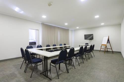 a conference room with a long table and chairs at Realce Hotel in Jaú