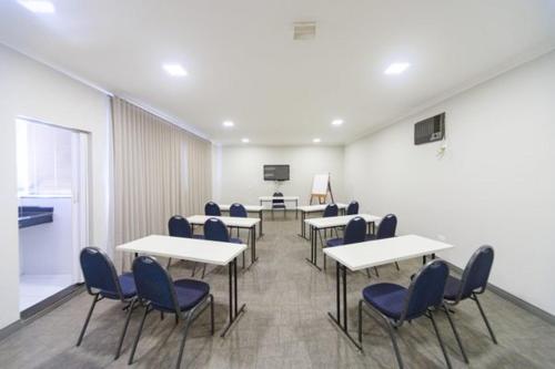 a classroom with tables and chairs in a room at Realce Hotel in Jaú