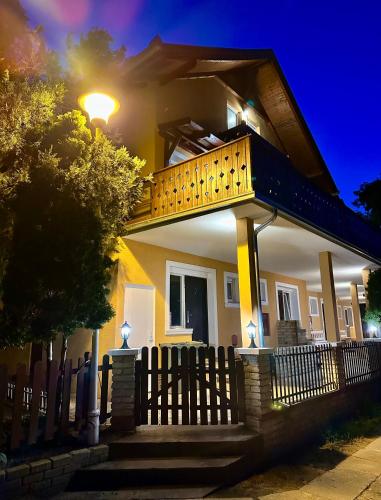 a house with a wooden fence in front of it at Kruna Palića in Palić