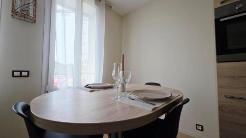 a wooden table with plates and wine glasses on it at LÉchappée ZAisne jacuzzi et sauna in Saint-Quentin
