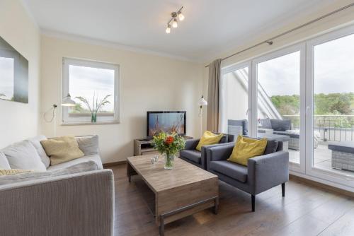 a living room with two couches and a table at Baltic Sea Lodge Küstenidyll in Scharbeutz
