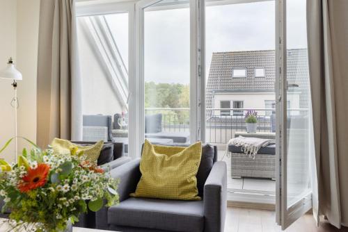 a living room with a gray couch and yellow pillows at Baltic Sea Lodge Küstenidyll in Scharbeutz