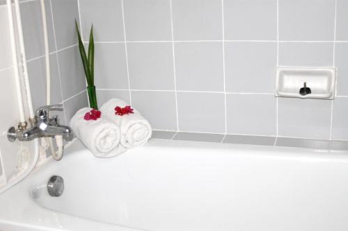 a bathroom with a bath tub with a flower vase at Paradise Hotel in Tanjung Pinang
