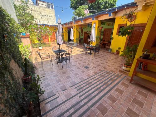 an outdoor patio with chairs and tables and umbrellas at Hotel Posada "Mi Rosita" in Oaxaca City