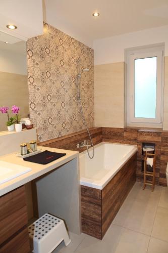 a bathroom with a tub and a sink at Paskal-Lux Apartments with Free Parking and AC in Budapest