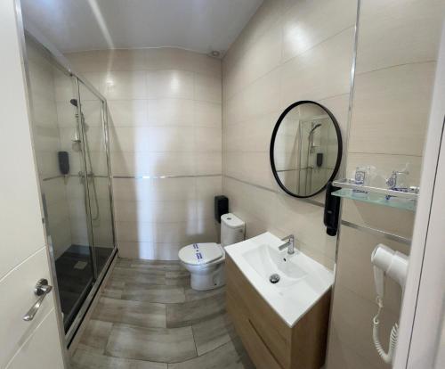 a bathroom with a toilet and a sink and a mirror at Hotel Zen Airport in Torremolinos