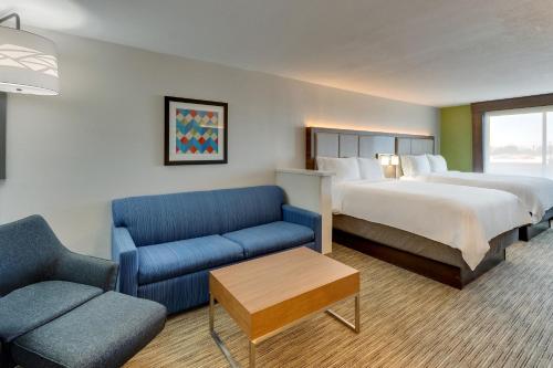 a hotel room with a bed and a couch at Holiday Inn Express Lake Worth NW Loop 820 by IHG in Fort Worth