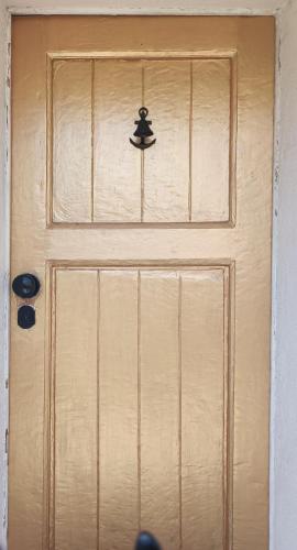 a wooden door with a hat on it at Happy Day Beach House in Costa da Caparica