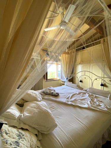 a canopy bed in a bedroom with a window at Cottage nel Chianti con piscina in Castellina in Chianti