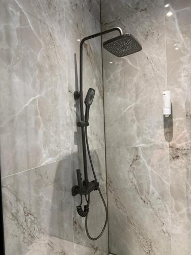 a shower in a bathroom with a stone wall at Galactic&Ludmila Suite SPA in Braşov