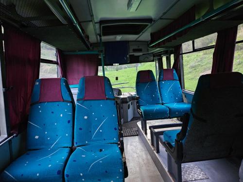 an empty bus with blue seats on a bus at Bed in Bus in Kolárovice