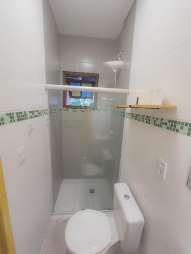 a white bathroom with a toilet and a shower at Biergarten Suites in Abraão