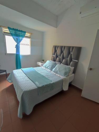 a bedroom with a large bed and a window at OUR HOME SAN ANTONIO in Cali