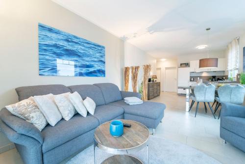 a living room with a blue couch and a table at Blankwasserweg 57 Wohnung 5 in Grömitz