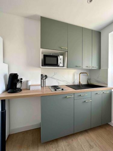 une cuisine avec un comptoir avec un micro-ondes dans l'établissement Petit cocon Toulonnais, à Toulon