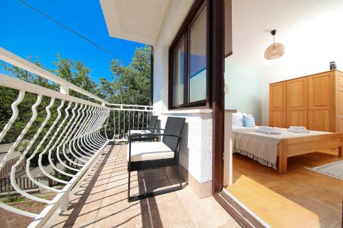 a balcony with chairs and a bed in a house at Apartments Kala in Jadranovo