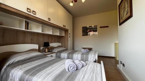 two beds in a room with towels on them at Villa Grifone in Sirmione