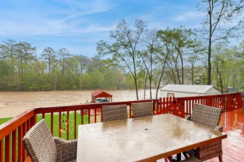 a wooden deck with a table and chairs and a river at The Wonder of Woodslake in Eatonton
