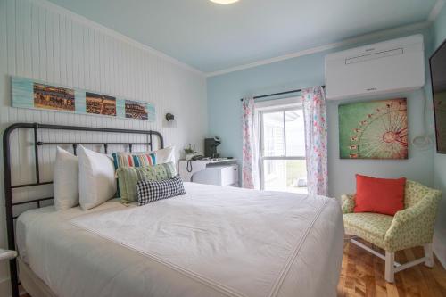 a bedroom with a large white bed and a chair at Ocean House Boutique Hotel & Motel in Old Orchard Beach