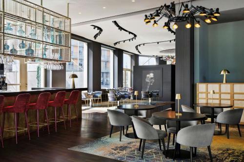 un restaurant avec des tables et des chaises et un bar dans l'établissement Renaissance Zurich Tower Hotel, à Zurich
