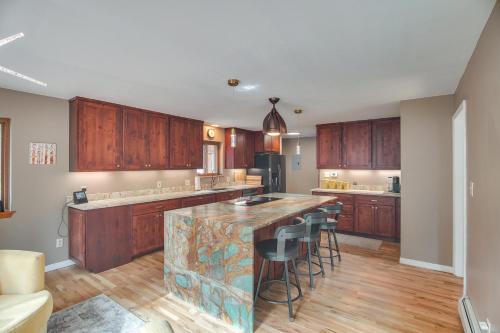 a kitchen with wooden cabinets and a island with bar stools at Riverfront Retreat in Nathrop Fire Pits and Hot Tub in Nathrop