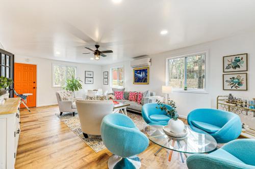 a living room with blue chairs and a table at Deck, Fire Pit and Pool Access at Poconos Retreat! in East Stroudsburg