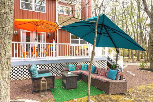 a patio with a couch and an umbrella at Deck, Fire Pit and Pool Access at Poconos Retreat! in East Stroudsburg