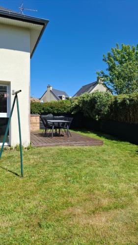 a picnic table in the grass next to a house at Mer et calme in Frehel