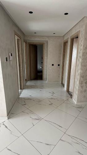 an empty room with white marble floors and walls at 2ch haut standing - calme & chic in Sale