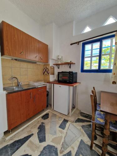 a kitchen with a sink and a microwave at Iliana's Bungalow in Arménoi