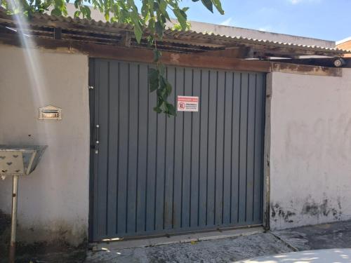 a green garage door with a sign on it at Casa AMORA 2 quartos PISCINA in Aparecida