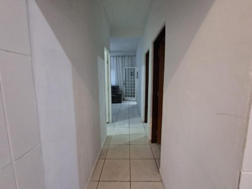 a hallway with white walls and a tile floor at Casa AMORA 2 quartos PISCINA in Aparecida