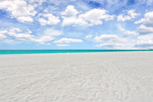 a sandy beach with a blue sky and clouds at Seabreeze at Anna Maria Island Inn in Bradenton Beach