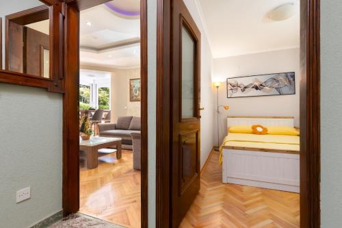 a bedroom with a bed and a living room at Apartment Dar & Mar in Herceg-Novi
