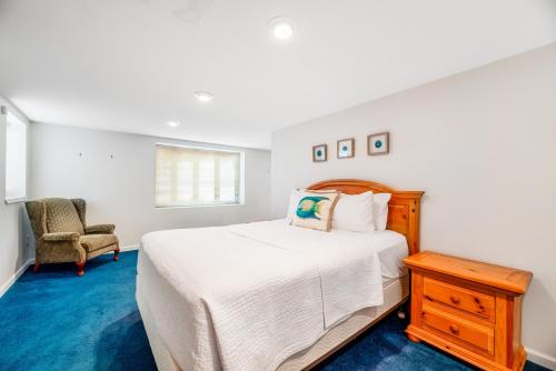 a white bedroom with a bed and a chair at Live Laugh Lake - A in Rushville