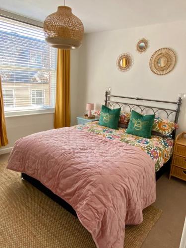 a bedroom with a large bed with green pillows at No 3, apartment in the heart of Bridport, Dorset in Bridport