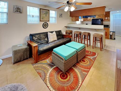 Una sala de estar con un sofá y una cocina. en Sugar Shack Bungalow, en Galveston