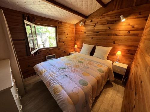 a bedroom with a bed in a wooden cabin at Résidence 083-le Verdon Sur Mer - 083 - Vue imprenable sur Port Médoc MAE-4421 in Le Verdon-sur-Mer